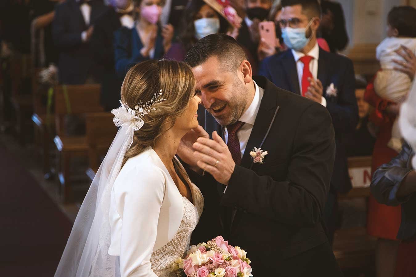 Novios compartiendo confidencias y sonrisas en el altar durante la ceremonia