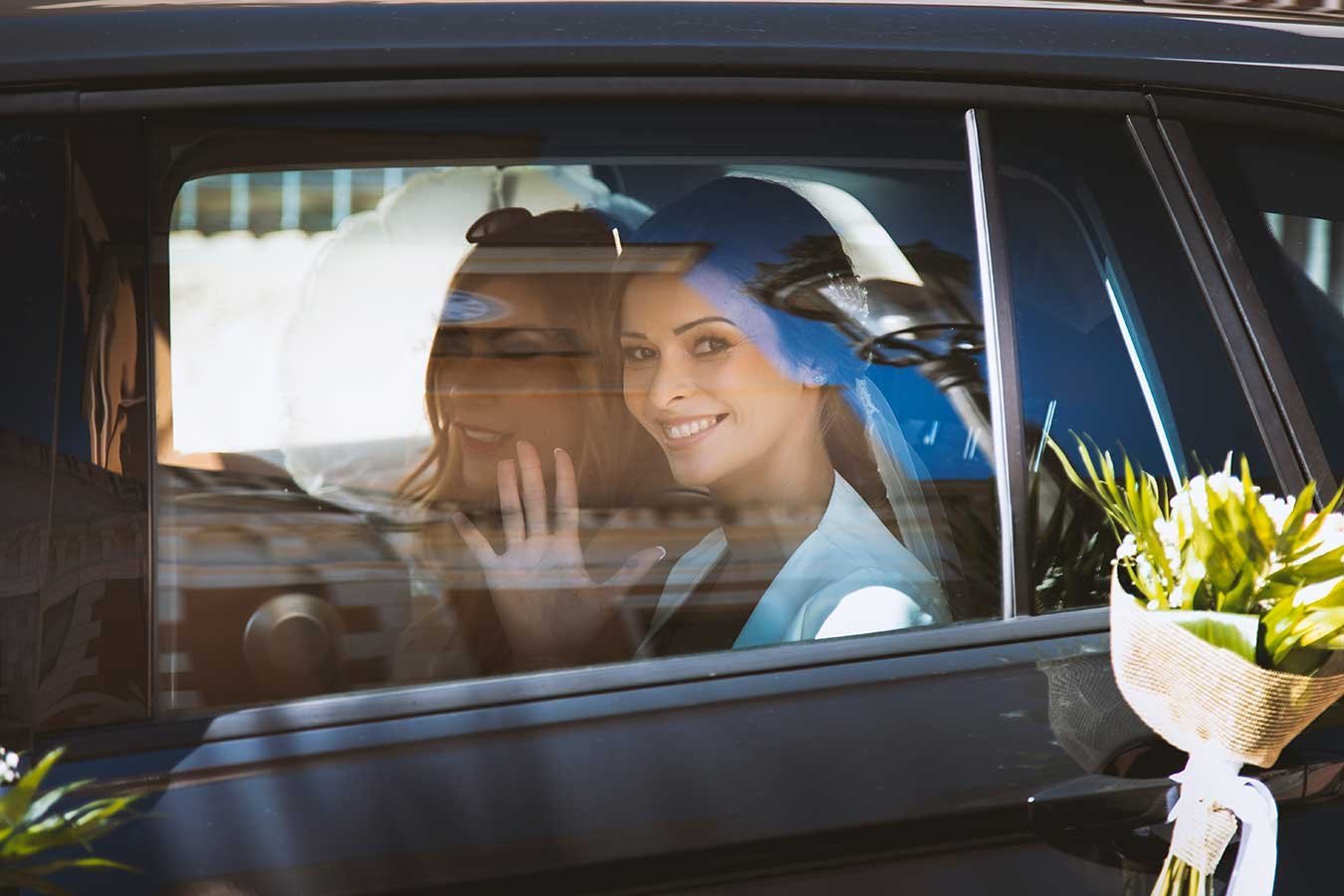 Reflejo de la novia sonriendo dentro del coche nupcial en Alicante
