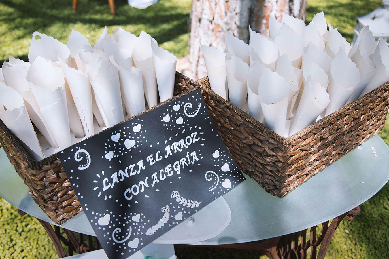 Cestas de mimbre decoradas con conos de papel con arroz y pétalos para el final de la ceremonia civil en la finca.