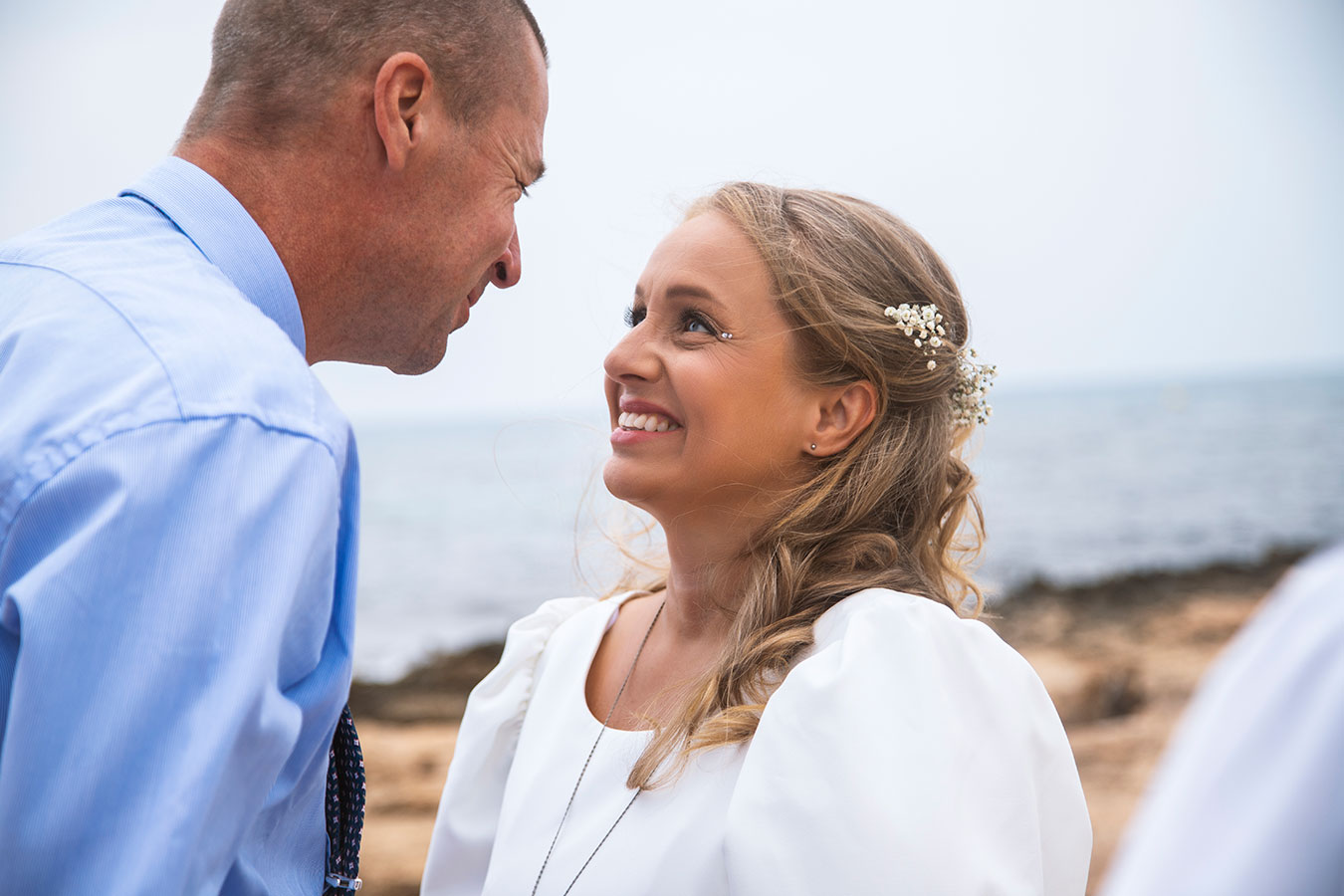 Novios sonriendo de cerca durante su ceremonia íntima al aire libre en Cala Ferris.