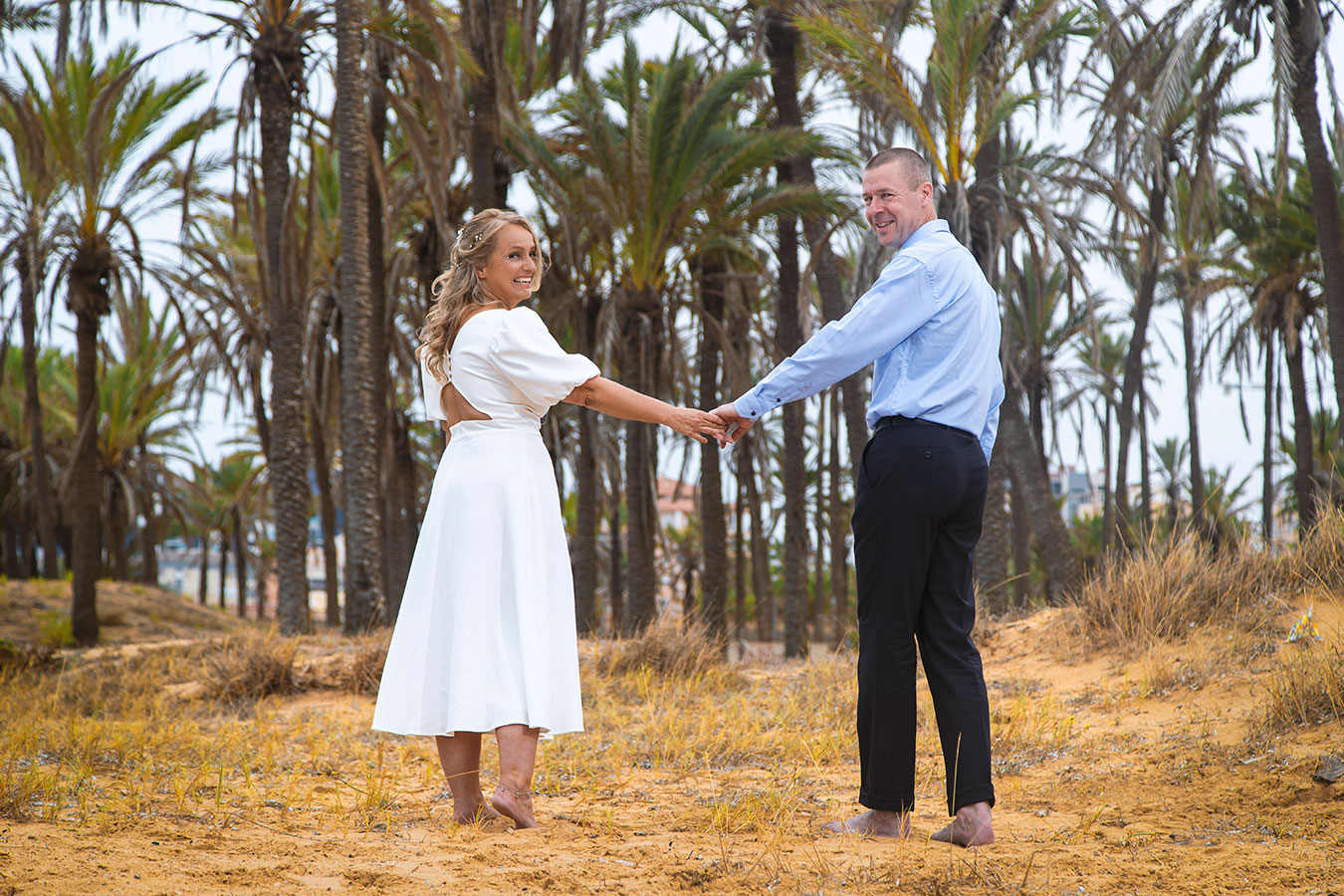 Novios caminando cogidos de la mano entre el palmeral natural de Cala Ferris en Torrevieja.
